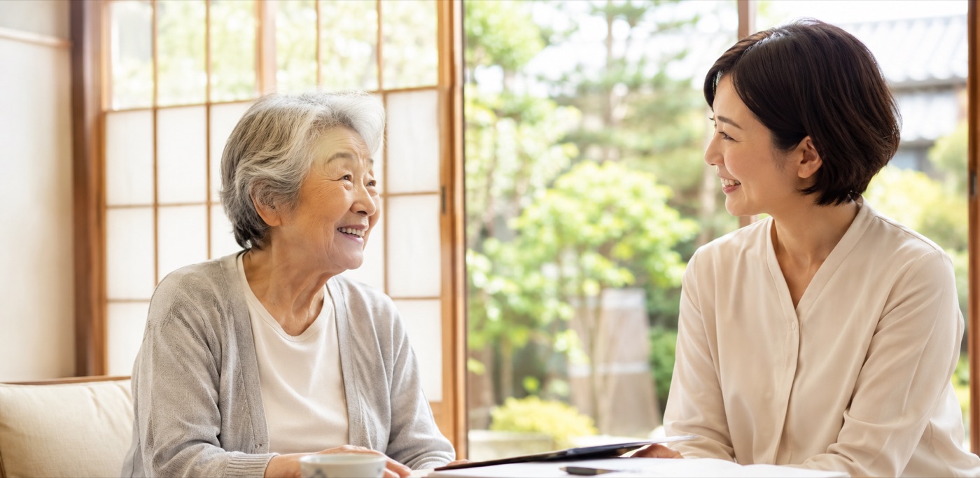 縁側で高齢の女性とスタッフが笑顔で会話している様子